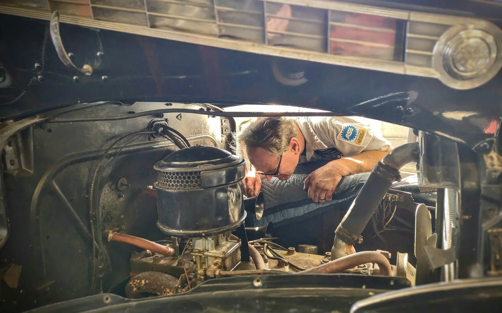 Experienced mechanic inspecting an engine under an open bonnet